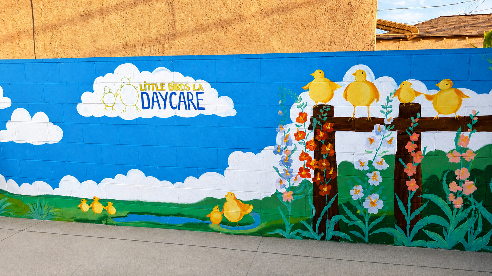 Hand-painted bird and garden mural on the backyard wall